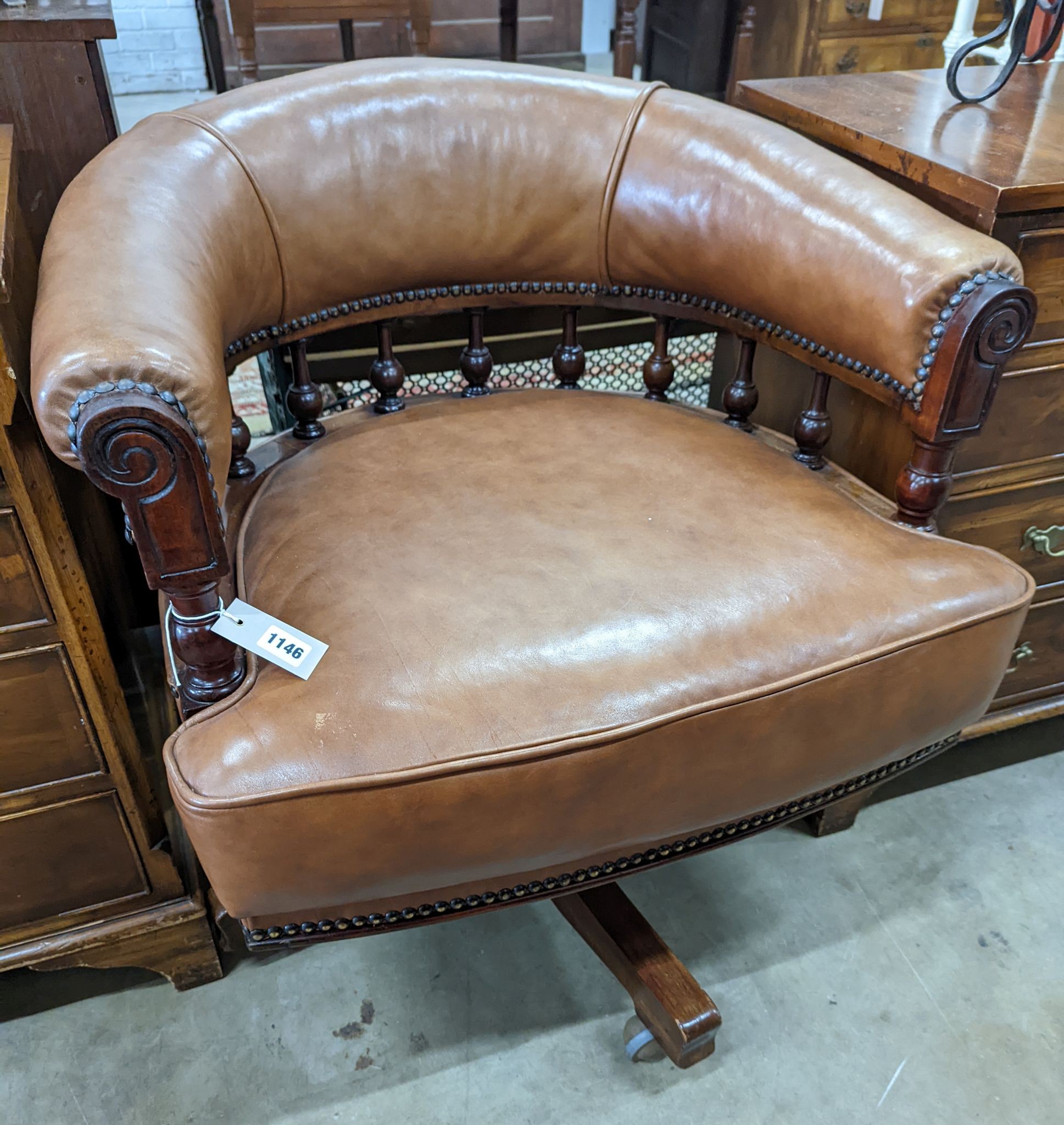 A late Victorian mahogany and tan leather swivel desk chair, width 68cm, depth 63cm, height 77cm